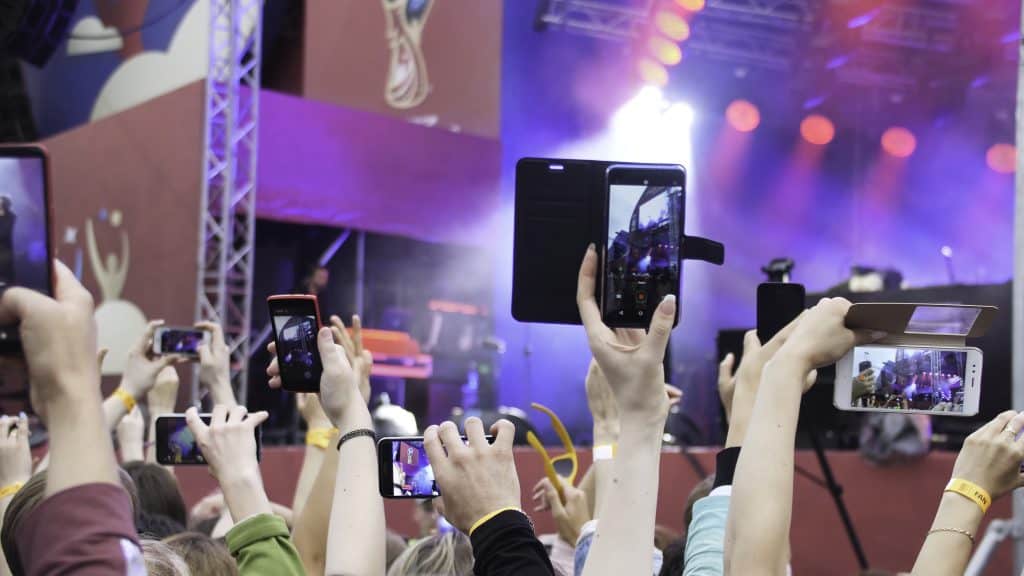 Group Of Young People Enjoying Outdoor Music Festival. Close-up rear view of crowd on concert. Funny